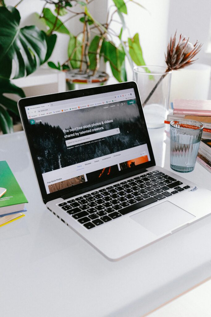 A stylish home office setup featuring a laptop on a desk surrounded by plants, capturing a calm work-from-home vibe.